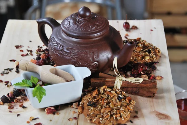 Braune Teekanne mit Tee und einem Plätzchen mit Samen und Karamell — Stockfoto