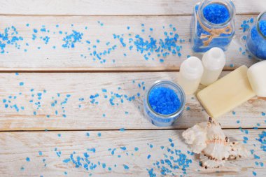 Mavi banyo tuzu gri sabun ve beyaz havlu ve f ile mini şampuan