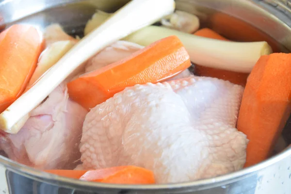 Darab nyers csirke egy fém pot sárgarépával, petrezselyemmel és c — Stock Fotó
