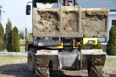 Bahçedeki toprak yükleme Ekskavatör