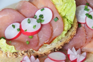 turp dilimleri ile bir marul yaprağı üzerinde füme jambon ile sandviç