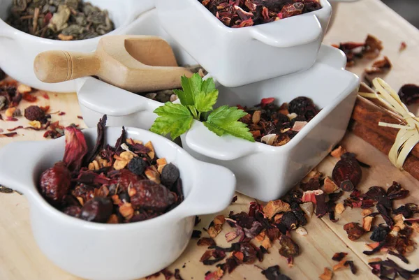 different types of tea dried in ceramic white containers, green