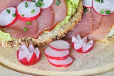 turp dilimleri ile bir marul yaprağı üzerinde füme jambon ile sandviç