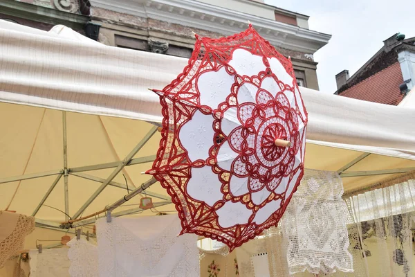 red crochet umbrella, handmade, work at a stand