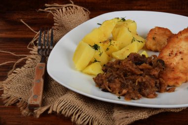 Kurutulmuş mantarlı kızarmış lahana, dereotlu haşlanmış patates ve domuz filetosu.