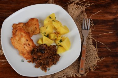 Kurutulmuş mantarlı kızarmış lahana, dereotlu haşlanmış patates ve domuz filetosu.