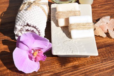 Havlu ve el yapımı sabunlar mor orkidenin yanında.