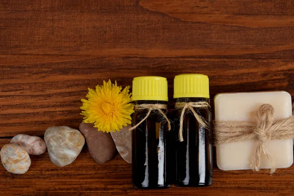 yellow dandelion flowers in the company of essential oils with empty space for text