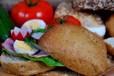 Marul, jambon ve haşlanmış yumurta halkaları, salatalık ve dereotlu sandviç.