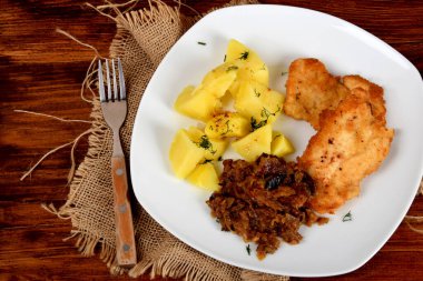 Kurutulmuş mantarlı kızarmış lahana, dereotlu haşlanmış patates ve domuz filetosu.