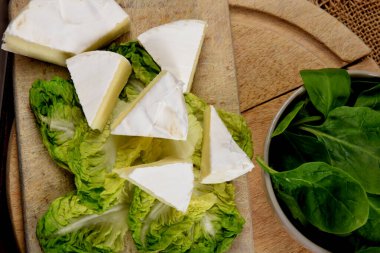 Mavi peynir ve ıspanak, ahşap mutfak tahtasındaki bir kasede.