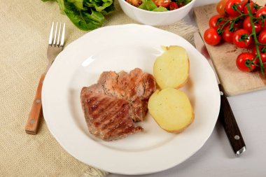 Kabuklu haşlanmış patatesli ızgara et.