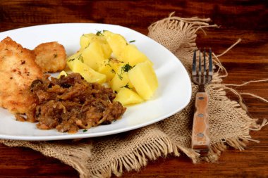 Kurutulmuş mantarlı kızarmış lahana, dereotlu haşlanmış patates ve domuz filetosu.