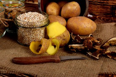 Soyulmuş patates ve arpa, kurutulmuş mantarların yanında kurutulmuş erikler ve kurutulmuş baharatlar.