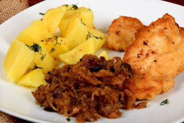 Kurutulmuş mantarlı kızarmış lahana, dereotlu haşlanmış patates ve domuz filetosu.