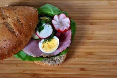 Marul, jambon ve haşlanmış yumurta halkaları, salatalık ve dereotlu sandviç.