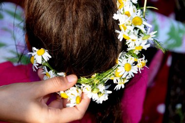Yaban çiçeklerinden bir çelenk örüyorum.