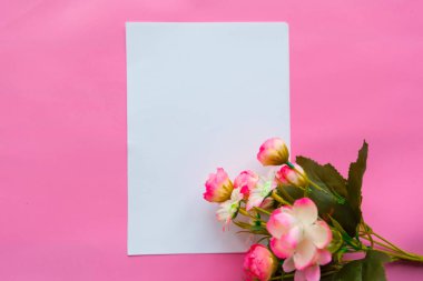 Beyaz, boş kâğıt ve pembe arka planda bir buket çiçek gibi. Sevgililer Günü mü Anneler Günü tebrik kartı mı?