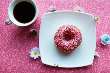 Çilekli çörek ve kahve fincanı masanın üstünde. 