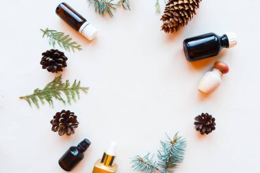 Beyaz arka planda kozmetik şişeler, koniler ve ladin dalları, üst manzara. Doğal kozmetik ürünleri konsepti