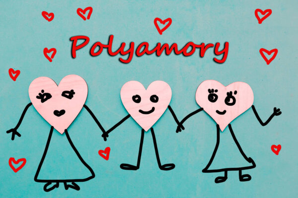 Three wooden hearts with draw faces hold hands - polyamory concept