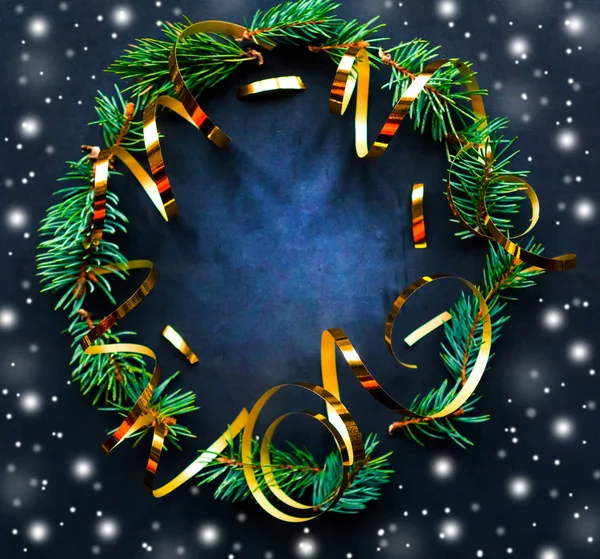 Christmas wreath with golden decorations on black background. Flat lay, top view, copy space. Merry Christmas and Happy New Year. Beautiful Xmas greeting card