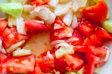 Taze domatesli bir tabak sebze salatası ve salatalık.