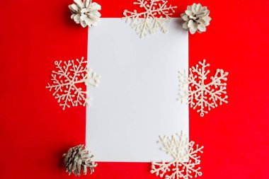 Beyaz model boş ve parlak kırmızı arka planda noel süslemeleri. Düz konum, üst görünüm, kopyalama alanı. Mutlu Noeller ve mutlu yıllar. Güzel Xmas tebrik kartı, banne