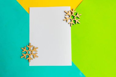 Geometrik mavi, yeşil ve sarı arka planda beyaz model boş ve noel süslemesi. Xmas tebrik kartı
