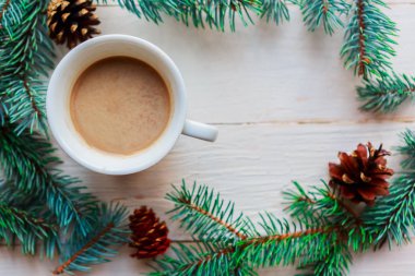 Noel kompozisyonu, beyaz ahşap arka planda kahve fincanı ve ladin dalları. Düz yerde, üst tarafta. Mutlu Noeller ve mutlu yıllar.