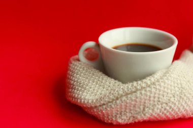 Kırmızı arka planda kahve fincanı ve kazak. Kış durgun, minimum yaşam