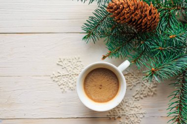 Beyaz ahşap arka planda kahve fincanı ve Noel süslemeleri. Düz konum, üst görünüm, kopyalama alanı