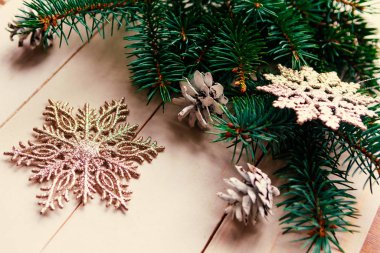 Noel gümüşü süslemeleri ve ahşap arka planda doğal ladin dalları.