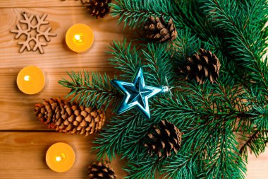 Noel ağacı ve ahşap zemin üzerinde mumlar olan bir Noel kompozisyonu.