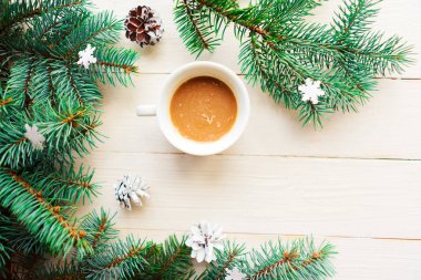 Noel kompozisyonu, beyaz ahşap arka planda Noel süslemeleri olan kahve fincanı ve ladin dalları. Düz yerde, üst tarafta. Mutlu Noeller ve mutlu yıllar.