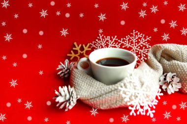 Parlak kırmızı arka planda Noel süslemeleri olan kahve fincanı. Xmas tebrik kartı