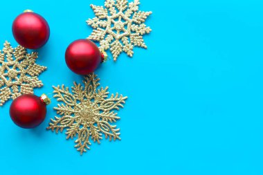 Parlak mavi arka planda gümüş kar taneleri olan kırmızı mücevherler. Düz konum, üst görünüm, kopyalama alanı. Xmas tebrik kartı. 