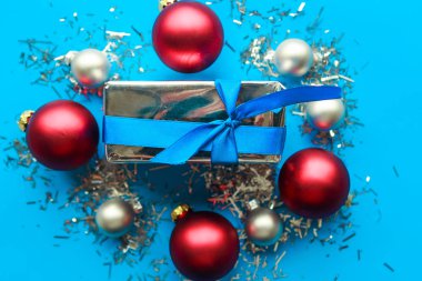 Hediye kutusu ve parlak mavi arka planda Noel mücevherleri