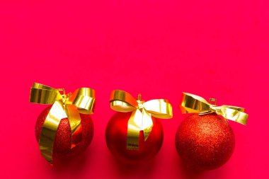 Parlak kırmızı arka planda altın kurdeleli üç kırmızı top. Düz konum, üst görünüm, kopyalama alanı, pankart