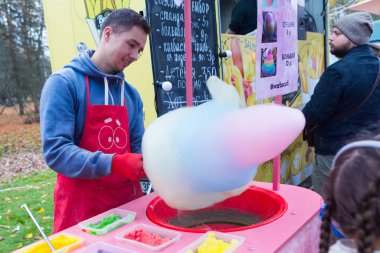 Minsk / Belarus - 31 Ekim 2019: Adam parkta pamuk şeker hazırlıyor