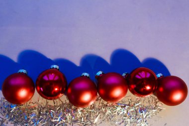 Gri kağıt arka planda Noel topları. Düz konum, üst görünüm, kopyalama alanı. Yapay ışık