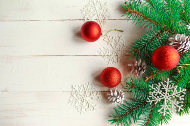 Külahlı ladin dalları ve beyaz ahşap arka planda kırmızı mücevherler. Noel ya da Yeni Yıl konsepti