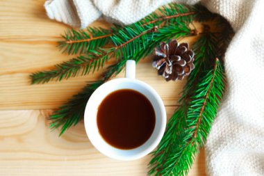 Noel kompozisyonu - kahve fincanı ve ağaç dalları ahşap arka planda. Düz konum, üst görünüm, kopyalama alanı. Mutlu Noeller tebrik kartı.