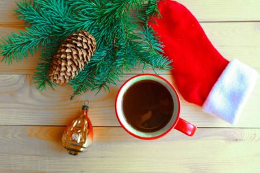 Noel kompozisyonu - kahve fincanı, ladin dalları ve tahta arka planda çoraplar. Düz konum, üst görünüm, kopyalama alanı