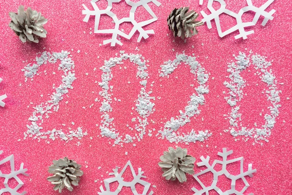 Number 2020 on pink glitter background. New Year concept