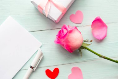 Aşk kompozisyonu - gül, hediye kutusu ve tahta arka planda maket kartı. Sevgililer Günü ya da düğün kartı.