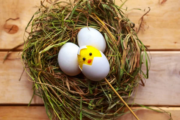 Toy chicken and eggs in hay nest. Easter concept