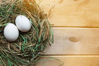 Saman yuvasında tavuk yumurtalarıyla çekilmiş düz bir fotoğraf. Paskalya konsepti. Boşluğu Kopyala