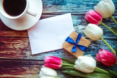 Kahve fincanı ve ahşap arka planda laleler.