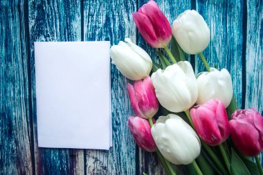 Kırmızı ve beyaz lale buketi ve tahta arka planda beyaz model, üst manzara. Metin için alanı kopyala